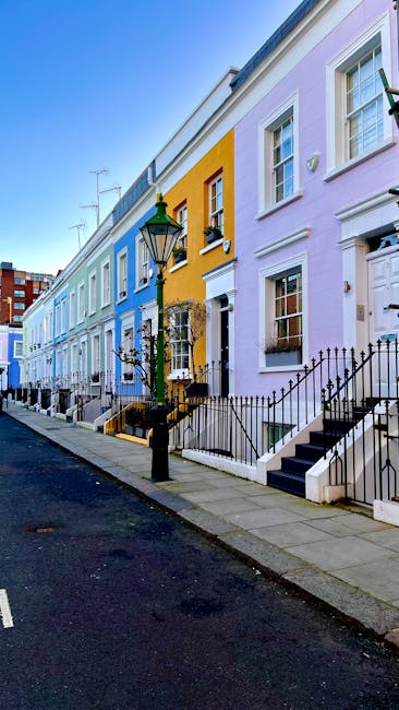 A cobblestone alleyway in South Kensington lined with two- and three-story white buildings on both sides, featuring large windows and black metal balconies. Potted plants and small trees in various co